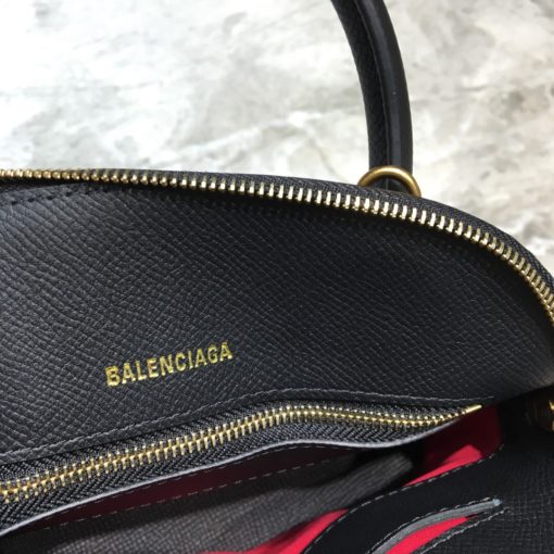 BALENCIAGA Mini Ville Logo Leather Bag. Original Quality Bag. Authentic Epi leather. Metal Toned Hardware. BALENCIAGA Sales Box and Dust Bag. Authenticity Card. BALENCIAGA's Ville mini bowling bag is crafted of grained calfskin printed with a large statement logo at the front and back. This design works as a zipped-top construction with a padlock charm to ensure your valuables are securely stowed. The versatile style can be carried by its rolled handles or over the shoulder via a detachable flat strap. | CRIS&COCO Authentic Quality Designer Bags and Luxury Accessories