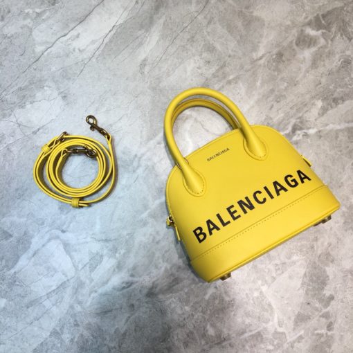 BALENCIAGA Mini Ville Logo Leather Bag. Original Quality Bag. Authentic Epi leather. Metal Toned Hardware. BALENCIAGA Sales Box and Dust Bag. Authenticity Card. BALENCIAGA's Ville mini bowling bag is crafted of grained calfskin printed with a large statement logo at the front and back. This design works as a zipped-top construction with a padlock charm to ensure your valuables are securely stowed. The versatile style can be carried by its rolled handles or over the shoulder via a detachable flat strap. | CRIS&COCO Authentic Quality Designer Bags and Luxury Accessories