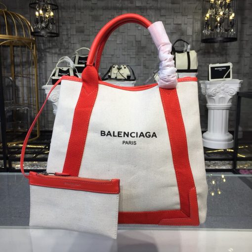 BALENCIAGA 'Cabas' Canvas and Leather Tote. Authentic Quality Bag with literature, dust bag, box and authenticity card. This Cabas tote has been made from Ecru canvas that's solely decorated with the iconic brand's updated logo lettering. Trimmed with smooth black leather at the edges and handles, it's fitted with snap fastenings at each side to create extra room on the days you need to carry your tablet or a notebook. | CRIS&COCO Authentic Quality bags and Accessories