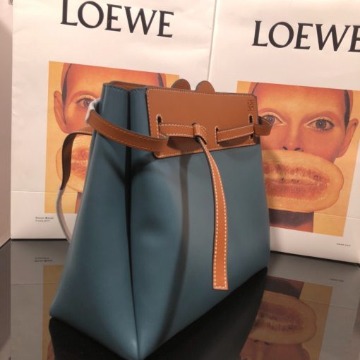 LOEWE Lazo Top Handle Bag. Authentic Quality Bag with literature, gift box, dust bag and authenticity card. A highly chic and sophisticated bag, the Lazo features the recognizable emblematic Gate knot. Contrasting calfskin straps holds the bag, cinching to fasten the bag effortlessly. Creating a sinuous accordion soft silhouette with soft natural calfskin, this novel interpretation is the next must-have chic functional bag of the season. The soft and slouchy calfskin bag is devoid of any zips for the closure and instead relies on the contrasting calfskin straps to cinch and fasten the opening. A relaxed update on a classic bag design. | CRIS&COCO Authentic Quality Designer Bags and Luxury Accessories