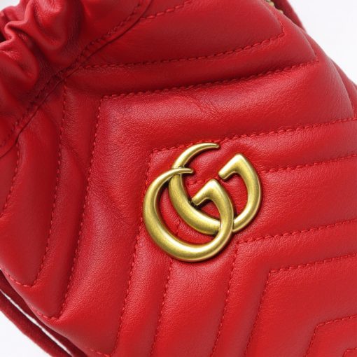 GUCCI GG Marmont Mini Bucket Bag. Original Quality Bag including gift box, literature, dust bag, authenticity card. The world of GG Marmont expands with the introduction of a mini bucket bag shape crafted from Matelassé leather in vibrant tones. Inspired by an archival design from the '70s, a hallmark era of the House, the Double G decorates the front of this accessory. Featuring a chain strap and drawstring closure the versatile shape can be worn as shoulder and as a crossbody bag. | Cris and Coco. High Quality Bags and Luxury Accessories