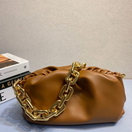 BOTTEGA VENETA The Chain Pouch. Original Quality Bag including gift box, literature, dust bag, authenticity card. BOTTEGA VENETA updates its cult Pouch bag with a chunky golden chain handle – a detail seen throughout the runway show. Crafted from supple Nappa leather in wear-with-anything shades, its magnetic frame is covered in voluminous folds that echo the brand's modern interpretation of its heritage. |CRIS AND COCO Authentic Quality Designer Bags and Luxury Accessories