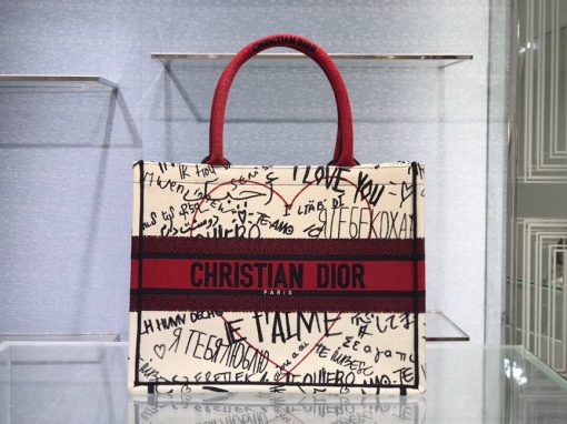 DIOR Book Tote. Original Quality Bag including gift box, care book, dust bag, authenticity card. This Book Tote is an original style introduced by Creative Director Maria Grazia Chiuri. This has become a staple of the Dior aesthetic. Ideally designed to carry all your daily essentials, the small shape is fully embroidered and the 'Christian Dior' signature on the front. This carryall is a perfect example of the Dior savoir-faire and also may be coordinated with a pouch or other small leather goods for a complete look. | CRIS&COCO Authentic Quality Designer Bags and Luxury Accessories