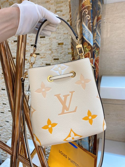 LOUIS VUITTON NéoNoé BB. Made from two-color Monogram Empreinte leather, the gradient pastel colorway of the Monogram Giant motif brings a festival feel to this resolutely on-trend NéoNoé BB bucket bag. It features a detachable top handle for hand and elbow carry as well as an adjustable strap for hand carry and over-the-shoulder wear. | CRIS&COCO Authentic Quality Designer Bags and Luxury Accessories