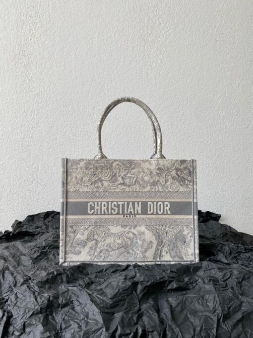 DIOR Book Tote. Original Quality Bag including gift box, care book, dust bag, authenticity card. This Book Tote is an original style introduced by Creative Director Maria Grazia Chiuri. This has become a staple of the Dior aesthetic. Ideally designed to carry all your daily essentials, the small shape is fully embroidered and the 'Christian Dior' signature on the front. This carryall is a perfect example of the Dior savoir-faire and also may be coordinated with a pouch or other small leather goods for a complete look. | CRIS&COCO Authentic Quality Designer Bags and Luxury Accessories