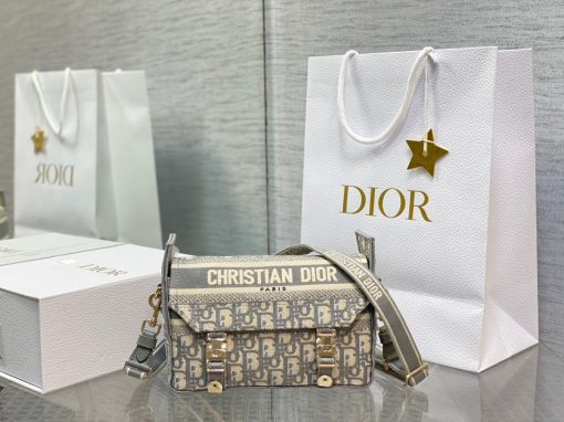 DIOR Small DiorCamp Bag. Original Quality Bag including gift box, care book, dust bag, authenticity card. Maria Grazia Chiuri has updated the classic messenger bag by adding signature Dior details for a relaxed and modern look. Fully embroidered with the Dior Oblique motif, the bag is enhanced by a 'CHRISTIAN DIOR PARIS' signature flap, as well as sportswear-inspired 'CD' buckles. Equipped with an adjustable and removable shoulder strap, the small, compact messenger bag can be worn over the shoulder or crossbody, and will make an ideal urban companion. | CRIS&COCO Authentic Quality Designer Bag and Luxury Accessories