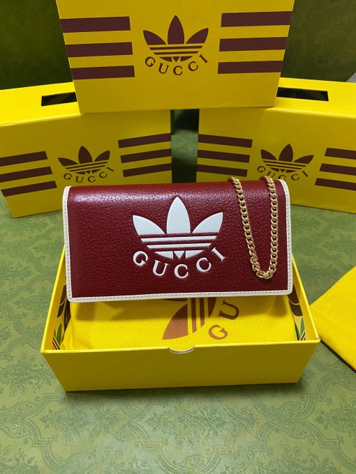 GUCCI X ADIDAS Wallet With Chain.  Original Quality Wallet including gift box, care book, dust bag, authenticity card. Part of the GUCCI X ADIDAS collection, this chain wallet features the Gucci Trefoil print. Emblematic House’s motifs mix with those of the historic sportswear brand adidas. The collection sees both heritages encoded in a trio of lines, where adidas and Gucci combine archival emblems. Creative Director, Alessandro Michele pulls inspiration from his memories of the ‘80s and ‘90s for a collection that is both nostalgia-driven and contemporary. | CRIS&COCO Authentic Quality Designer Bag and Luxury Accessories