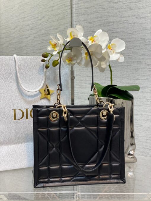 DIOR Essential Tote Bag. Original Quality Bag including gift box, care book, dust bag, authenticity card. A new House staple debuted at the Fall-Winter 2022-2023 ready-to-wear fashion show, the Dior Essential tote bag presents a functional design with modern elegance. Crafted in satin-finish calfskin, it is adorned with the Archicannage motif offering a new take on the iconic House topstitching. The spacious interior features three patch pockets and one zipped pocket to accommodate all of the essentials. Featuring leather and pale gold-finish metal chain top handles, the tote may be worn over the shoulder or carried by hand as an ideal daily companion. | CRIS&COCO Authentic Quality Designer Bag and Luxury Accessories