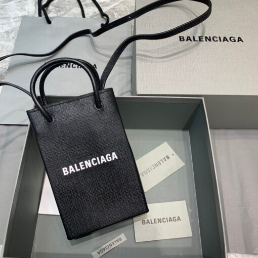 BALENCIAGA Mini Shopping Bag. Original Quality Bag including gift box, care book, dust bag, authenticity card. A new season may be here, but the frenzy for logomania is far from over. At the helm of the trend, Balenciaga continues to offer branded styles. Case in point: this mini shopping bag. Featuring round top handles, a shoulder strap, a strap closure, a main internal compartment and a printed logo to the front. | CRIS&COCO Authentic Quality Designer Bags and Luxury Accessories