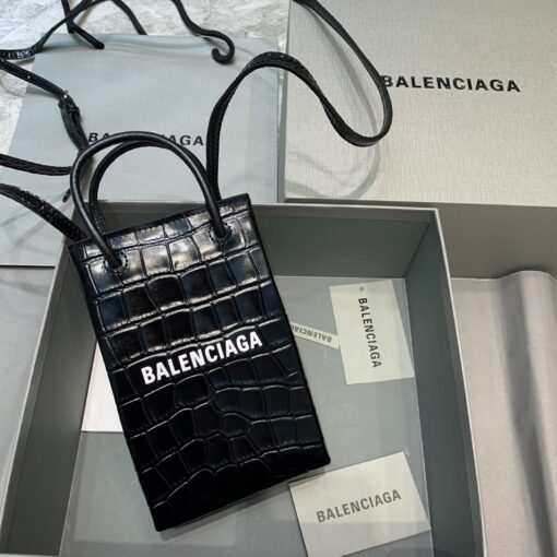 BALENCIAGA Mini Shopping Bag. Original Quality Bag including gift box, care book, dust bag, authenticity card. A new season may be here, but the frenzy for logomania is far from over. At the helm of the trend, Balenciaga continues to offer branded styles. Case in point: this mini shopping bag. Featuring round top handles, a shoulder strap, a strap closure, a main internal compartment and a printed logo to the front. | CRIS&COCO Authentic Quality Designer Bags and Luxury Accessories