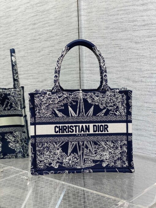 DIOR Small Book Tote. Original Quality Bag including gift box, care book, dust bag, authenticity card. This DIOR Tote is an original creation introduced by Dior's Creative Director, Maria Grazia Chiuri, and has become a staple of the Dior aesthetic. Designed to hold all the daily essentials, it is fully embroidered. Adorned with a Christian Dior Paris signature on the front, the small tote exemplifies the House's signature savoir-faire and may be carried by hand. | CRIS&COCO Authentic Quality Designer Bags and Luxury Accessories