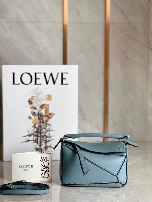 LOEWE Mini Puzzle Bag. Original Quality Bag including gift box, care book, dust bag, authenticity card. The Puzzle bag is the debut bag for LOEWE by Creative Director Jonathan Anderson. A cuboid shape and precise cutting technique create Puzzle’s distinctive geometric lines. This mini version is crafted in contrasting calfskins. | CRIS AND COCO Authentic Quality Luxury Accessories