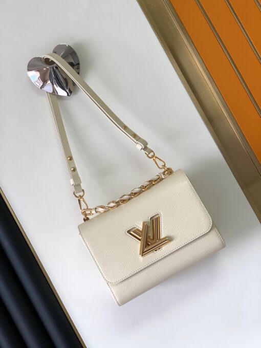 LOUIS VUITTON Twist MM. Original Quality Bag including gift box, care book, dust bag, authenticity card. This glamourous Twist MM handbag is made from deep-dyed Epi grained leather and adorned with a detachable chunky gold-color chain, braided with leather. The braiding on the chain reflects Louis Vuitton’s superior leather craftsmanship. The chain is perfect for hand carry while a removable strap allows shoulder and cross-body carry. | CRIS AND COCO Authentic Quality Luxury Accessories