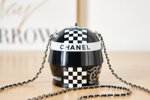 CHANEL Helmet Minaudiere. High-End Quality Bag including gift box, care book, dust bag, authenticity card. This precious creation was unveiled along with the Slot Machine Minaudière and Sphere Minaudière at #CHANELCruise 2023. The 11 cm by 10 cm objet d’art sees diamanté crystals and Chanel logos peppering the full resin exterior for maximum effect. Capturing attention in eye-catching black, red and white, it is equal parts clutch and eye candy. | CRIS AND COCO Authentic Quality Luxury Accessories