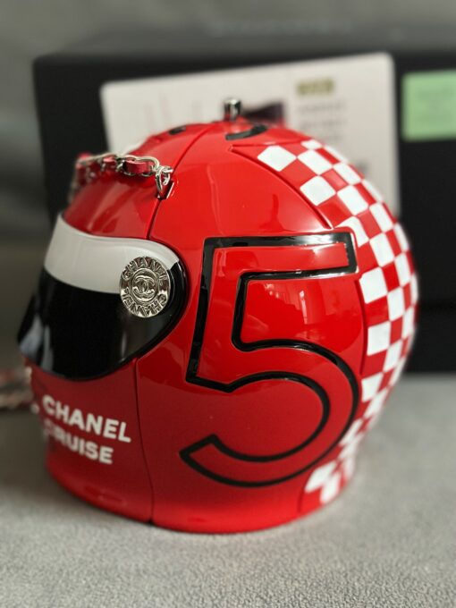 CHANEL Helmet Minaudiere. High-End Quality Bag including gift box, care book, dust bag, authenticity card. This precious creation was unveiled along with the Slot Machine Minaudière and Sphere Minaudière at #CHANELCruise 2023. The 11 cm by 10 cm objet d’art sees diamanté crystals and Chanel logos peppering the full resin exterior for maximum effect. Capturing attention in eye-catching black, red and white, it is equal parts clutch and eye candy. | CRIS AND COCO Authentic Quality Luxury Accessories