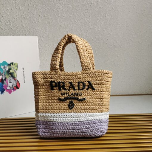 PRADA Small Crochet Tote Bag. Elevate Your Look with an Exquisite Tote Bag! This exquisite tote bag has a deconstructed design made of a light, natural material with a summery mood, raffia-effect yarn. Embroidered lettering logo decorates the front, and the emblematic triangle in enameled metal is the perfect finishing touch to the side. | CRIS&COCO Authentic Quality Designer Bags and Luxury Accessories