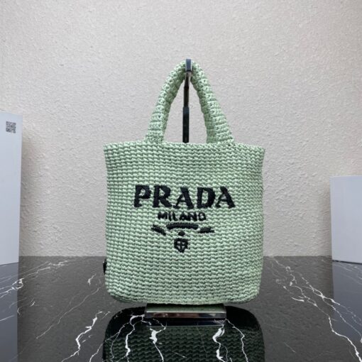 PRADA Small Crochet Tote Bag. Elevate Your Look with an Exquisite Tote Bag! This exquisite tote bag has a deconstructed design made of a light, natural material with a summery mood, raffia-effect yarn. Embroidered lettering logo decorates the front, and the emblematic triangle in enameled metal is the perfect finishing touch to the side. | CRIS&COCO Authentic Quality Designer Bags and Luxury Accessories