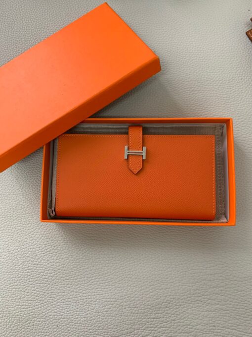 HERMÈS Béarn Wallet: Where Elegance Meets Functionality, Inspired by the Heart of France's South-West. The Béarn pays homage to the enchanting South-West region of France and stands as a distinguished member of a collection that honors various distinctive French regions. This wallet or card holder boasts an elegantly sleek design and is thoughtfully equipped with multiple compartments tailored for organizing credit cards, coins, and bills with ease. Upon closure, a supple leather flap gracefully glides into an iconic "H" shaped clasp, elevating it to a timeless classic. It presents a generous array of leather types and colors, allowing one to harmonize effortlessly with the latest trends in style.