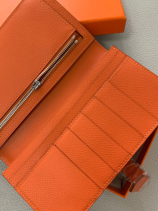 HERMÈS Béarn Wallet: Where Elegance Meets Functionality, Inspired by the Heart of France's South-West. The Béarn pays homage to the enchanting South-West region of France and stands as a distinguished member of a collection that honors various distinctive French regions. This wallet or card holder boasts an elegantly sleek design and is thoughtfully equipped with multiple compartments tailored for organizing credit cards, coins, and bills with ease. Upon closure, a supple leather flap gracefully glides into an iconic "H" shaped clasp, elevating it to a timeless classic. It presents a generous array of leather types and colors, allowing one to harmonize effortlessly with the latest trends in style.