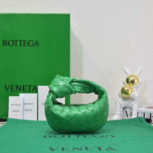 BOTTEGA VENETA Mini Jodie. Mini Marvel: Elevate Your Essentials. Introducing the BV Mini Jodie by Daniel Lee, a captivating embodiment of the mini bag trend infused with a beautiful minimalist essence. True to the distinctive allure of the Jodie collection, this rendition showcases the iconic Intrecciato weave and the signature knot embellishment. Delicately compact, it effortlessly nestles under your arm like a charming baguette bag yet offers ample space for essentials such as your phone, cards, and keys. Despite its diminutive size, this mini bag radiates a vibrant aura through various lively hues, ensuring it leaves a memorable impression.