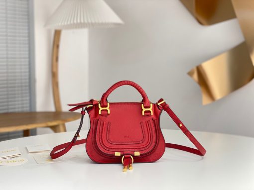 CHLOÉ Marcie Mini Double Carry Bag: Elegance in Miniature. Introducing a charming, petite rendition of the iconic Marcie handbag, this mini double carry bag exudes elegance with its meticulous craftsmanship in grained calfskin. Its clean, sleek lines and gracefully contoured design elevate the relaxed, slouchy silhouette, while the hand-wrapped leather handles impart an artisanal touch. The addition of metallic buckles bestows a polished and refined finish to this exquisite creation. Equipped with both double handles and a long, detachable shoulder strap, this mini bag epitomizes versatility, making it a must-have accessory for any occasion.