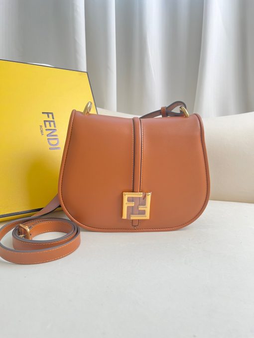 FENDI C’mon Medium. Timeless Elegance, Embodied in Leather. Elegantly designed, this medium-sized satchel bag boasts graceful, curved lines that exude femininity. Its elongated flap is adorned with a striking metal FF logo, adding a touch of sophistication to its overall charm. Crafted from supple leather with meticulously embossed edges and intricate details, this bag radiates a sense of refined luxury. The sides of the bag seamlessly blend with the overall design, crafted from the same tone-on-tone full-grain leather, ensuring a harmonious and visually pleasing aesthetic.