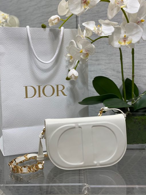 DIOR CD Signature Bag with Strap. Modern Elegance, Timeless Signature. Introducing the CD Signature Bag for Fall 2023—a perfect blend of modern sophistication and timeless elegance. Expertly crafted from black box calfskin, this bag stands out with its embossed CD signature on the front, showcasing the House's exceptional craftsmanship. The thoughtfully designed gusseted compartment and patch pocket keep your daily essentials neatly organized. The medium-sized bag features a flap closure and a chain shoulder strap with CD signature links interwoven with leather, allowing for versatile wear—whether over the shoulder or crossbody.