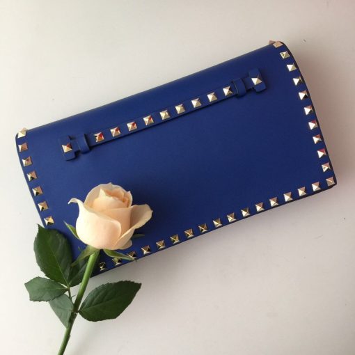 VALENTINO The Rockstud Leather Clutch. Authentic quality luxury bag crafted in genuine leather comes with authenticity card, dust bag and gift bag. Iconic Elegance in Every Detail. This Rockstud Leather Clutch is a compact and luxurious clutch made with high-quality leather and adorned with signature Rockstud detailing. It features a detachable wrist strap and is perfect for carrying essentials. The sleek design and brand logo embossing make it an ideal accessory for special occasions.