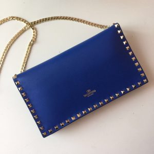 VALENTINO The Rockstud Leather Clutch. Authentic quality luxury bag crafted in genuine leather comes with authenticity card, dust bag and gift bag. Iconic Elegance in Every Detail. This Rockstud Leather Clutch is a compact and luxurious clutch made with high-quality leather and adorned with signature Rockstud detailing. It features a detachable wrist strap and is perfect for carrying essentials. The sleek design and brand logo embossing make it an ideal accessory for special occasions. - KRIS + KIKO Original highest quality bgs. Authentic design. Genuine Material. Affordable Luxury. Handbags and Accessories.