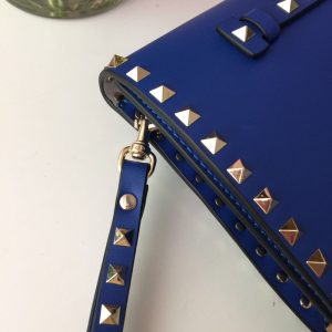 VALENTINO The Rockstud Leather Clutch. Authentic quality luxury bag crafted in genuine leather comes with authenticity card, dust bag and gift bag. Iconic Elegance in Every Detail. This Rockstud Leather Clutch is a compact and luxurious clutch made with high-quality leather and adorned with signature Rockstud detailing. It features a detachable wrist strap and is perfect for carrying essentials. The sleek design and brand logo embossing make it an ideal accessory for special occasions. - KRIS + KIKO Original highest quality bgs. Authentic design. Genuine Material. Affordable Luxury. Handbags and Accessories.
