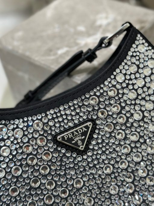 PRADA Cleo Satin Bag With Crystals. Authentic quality luxury bag crafted in genuine leather comes with authenticity card, dust bag and gift bag. Satin Sophistication, Crystal Charisma, Iconic Elegance The Prada Cleo bag exudes a sense of femininity, elegance, and modernity. Crafted from luxurious satin and adorned with sparkling crystals of varying sizes, this bag possesses an exquisite allure. Its graceful curves, reminiscent of classic designs from Prada's archives, contribute to its iconic