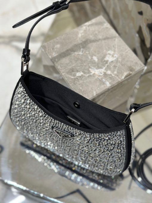 PRADA Cleo Satin Bag With Crystals. Authentic quality luxury bag crafted in genuine leather comes with authenticity card, dust bag and gift bag. Satin Sophistication, Crystal Charisma, Iconic Elegance The Prada Cleo bag exudes a sense of femininity, elegance, and modernity. Crafted from luxurious satin and adorned with sparkling crystals of varying sizes, this bag possesses an exquisite allure. Its graceful curves, reminiscent of classic designs from Prada's archives, contribute to its iconic