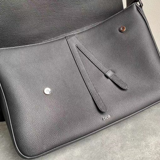 DIOR Saddle Messenger Bag. Authentic quality luxury bag crafted in genuine leather comes with authenticity card, dust bag and gift bag. Elegance Meets Functionality. Introducing the Saddle messenger bag, an understated yet sophisticated choice with a timeless silhouette. Meticulously crafted from high-quality black grained calfskin, this splendid accessory showcases a flap adorned with iconic Saddle lines, beautifully complemented by a tasteful 'DIOR' signature. Its versatile adjustable shoulder strap enables effortless wear, whether over the shoulder or crossbody. Inside, the spacious interior presents a practical patch pocket, generously accommodating a 13-inch laptop, important documents, and even a tablet. With its seamless blend of style and functionality, this bag is an ideal companion for your everyday needs.