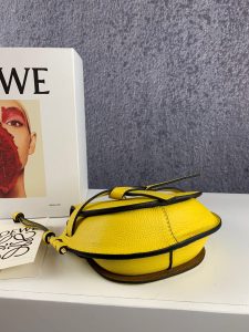 LOEWE Gate Mini Grained-Leather Cross-Body Bag. Authentic quality luxury bag crafted in genuine leather comes with authenticity card, dust bag and gift bag. Signature Finesse Meets Micro-Mini Trend. Loewe introduces its own elegant twist to the micro-mini bag trend with this charming red version of the coveted Gate style. Drawing inspiration from the fastenings found on countryside gates, this Gate cross-body bag is expertly crafted from luxurious grained leather. The bag showcases a delightful half-moon shape and features a long shoulder strap, beautifully finished with black lacquered edges. Opening up to a suede interior, it reveals a convenient slip pocket for essential belongings. - KRIS + KIKO LOEWE Gate Mini Grained-Leather Cross-Body Bag. Authentic quality luxury bag crafted in genuine leather comes with authenticity card, dust bag and gift bag. Signature Finesse Meets Micro-Mini Trend. Loewe introduces its own elegant twist to the micro-mini bag trend with this charming red version of the coveted Gate style. Drawing inspiration from the fastenings found on countryside gates, this Gate cross-body bag is expertly crafted from luxurious grained leather. The bag showcases a delightful half-moon shape and features a long shoulder strap, beautifully finished with black lacquered edges. Opening up to a suede interior, it reveals a convenient slip pocket for essential belongings.
