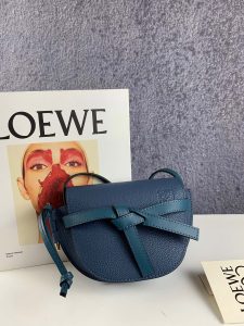 LOEWE Gate Mini Grained-Leather Cross-Body Bag. Authentic quality luxury bag crafted in genuine leather comes with authenticity card, dust bag and gift bag. Signature Finesse Meets Micro-Mini Trend. Loewe introduces its own elegant twist to the micro-mini bag trend with this charming red version of the coveted Gate style. Drawing inspiration from the fastenings found on countryside gates, this Gate cross-body bag is expertly crafted from luxurious grained leather. The bag showcases a delightful half-moon shape and features a long shoulder strap, beautifully finished with black lacquered edges. Opening up to a suede interior, it reveals a convenient slip pocket for essential belongings. - KRIS + KIKO LOEWE Gate Mini Grained-Leather Cross-Body Bag. Original Quality Bag. Authentic Style. Genuine Calf Leather. Metal Hardware. Authentic Packaging. Original Quality Dust Bag. Loewe brings signature finesse to the micro-mini bag trend with this tiny red iteration of its coveted Gate style. The bag takes inspiration from countryside gate latch fastenings to create this grained-leather Gate cross-body bag. It's crafted to a half-moon shape with a long shoulder strap that is finished with black lacquered edges, then opens to reveal a suede interior with a single slip pocket.