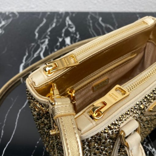 PRADA Galleria Satin Mini Bag With Crystals. Authentic quality luxury bag crafted in genuine leather comes with authenticity card, dust bag and gift bag. Timeless Elegance Meets Dazzling Crystals The Prada Galleria bag is a stunning creation adorned with a surface of brilliant crystals in various sizes, evoking the world of exquisite jewelry. This accessory is a shining testament to Prada's century-long dedication to crafting luxury leather goods, showcasing the brand's modernity and distinctive style. With its pragmatic design and structured lines, the bag captures the essence of contemporary flair, while retaining a touch of timeless elegance. Crafted from luxurious silk satin and presented in a mini version, this bag pays homage to the historic Prada store established by Mario Prada in 1913 within the Galleria Vittorio Emanuele II in Milan. In essence, the Prada Galleria bag encapsulates the brand's enduring legacy of refined sophistication.
