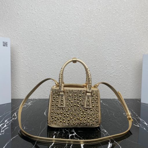 PRADA Galleria Satin Mini Bag With Crystals. Authentic quality luxury bag crafted in genuine leather comes with authenticity card, dust bag and gift bag. Timeless Elegance Meets Dazzling Crystals The Prada Galleria bag is a stunning creation adorned with a surface of brilliant crystals in various sizes, evoking the world of exquisite jewelry. This accessory is a shining testament to Prada's century-long dedication to crafting luxury leather goods, showcasing the brand's modernity and distinctive style. With its pragmatic design and structured lines, the bag captures the essence of contemporary flair, while retaining a touch of timeless elegance. Crafted from luxurious silk satin and presented in a mini version, this bag pays homage to the historic Prada store established by Mario Prada in 1913 within the Galleria Vittorio Emanuele II in Milan. In essence, the Prada Galleria bag encapsulates the brand's enduring legacy of refined sophistication.