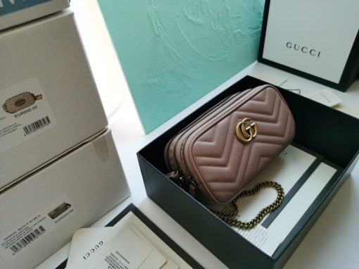 GUCCI GG Marmont Mini Chain Bag. Authentic quality luxury bag crafted in genuine leather comes with authenticity card, dust bag and gift bag. Style meets functionality in a compact and adorable package. The GG Marmont Mini Chain Bag is exquisitely adorned with chevron leather and features a delightful heart embellishment on its back. Its slender, softly structured form boasts three convenient zippered compartments. The front showcases the ultra-stylish GG logo, painstakingly crafted with antique gold hardware, lending a touch of vintage charm. The interior is lined with moiré and microfiber, pleasantly resembling suede. In addition, two card slots and a 60cm drop chain strap are included. Despite its compact size, this bag is undeniably cute, especially when elegantly draped over the shoulder.