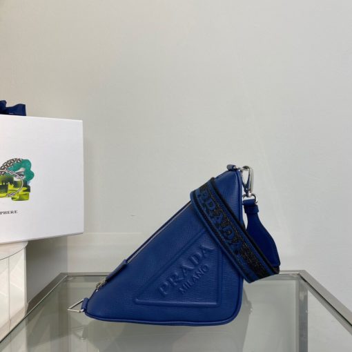 PRADA Saffiano Triangle Bag. Authentic quality luxury bag crafted in genuine leather comes with authenticity card, dust bag and gift bag. Artistry Meets Sustainability in Every Stitch. Crafted from Saffiano leather, a distinguished material recognized for its signature crosshatched pattern and waxed coating, this triangle-shaped bag epitomizes Prada's iconic geometric design. The emblematic triangle logo is skillfully embossed on the front, adding a touch of artistry. To further enhance the impeccable craftsmanship, the bag incorporates a Re-Nylon lining, a cutting-edge fabric crafted from regenerated nylon yarn. This exquisite combination of style and sustainability beautifully completes the overall design.
