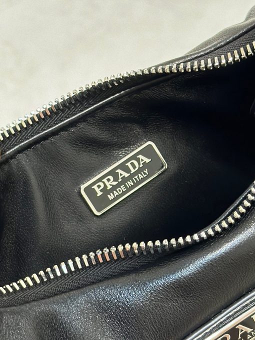 PRADA Soft Padded Mini Bag. Authentic quality luxury bag crafted in genuine leather comes with authenticity card, dust bag and gift bag. Elevate your style with the harmonious allure of this mini bag. This mini-bag crafted from padded leather with a detachable, adjustable shoulder strap exudes a harmonious and confident silhouette. Its versatility shines through with a zipper closure and the iconic enameled metal triangle logo adds a stylish touch to its design.