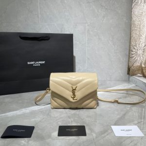 SAINT LAURENT Toy Loulou Matelassé Mini Bag. Authentic quality luxury bag crafted in genuine leather comes with authenticity card, dust bag and gift bag. Embrace Your Inner Rock and Roll Chic. The SAINT LAURENT Toy Loulou Matelassé Mini Bag can be described as a beautifully feminine accessory with a touch of rebellious charm. Its standout feature is the padded quilted leather, which adds volume and texture. The leather chain handles and metal interlocking YSL initials on the front flap give the bag a daring yet timeless allure, making it a luxurious statement piece. The versatility of the YSL LouLou bag is truly impressive, as it can effortlessly transition from casual to formal occasions. The adjustable chain strap allows for the option of wearing it as a crossbody bag, adding to its adaptability. - KRIS + KIKO SAINT LAURENT Toy Loulou Matelassé Mini Bag. If asked to describe the design of the SAINT LAURENT Toy Loulou Matelassé Mini Bag in a few words, we’d say that it is a feminine bag with a slight rock and roll feel to it. One of the most noticeable things about the look of the LouLou is the padded quilted leather, a feature which gives the bag more volume. The leather padded chain handles and the metal interlocking YSL initials on the front flap, make it a bold, yet still classic, luxury handbag. Versatility is another strong point of the YSL LouLou bag, and it can definitely be dressed up or down for any occasion. The chain strap is moveable, which means it can also be worn as a crossbody bag.