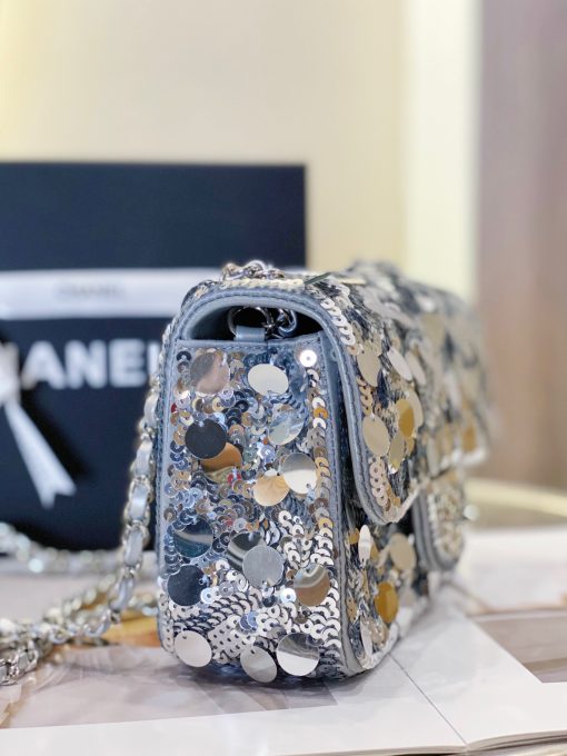 CHANEL Mini Flap Bag In Sequins. Authentic quality luxury bag comes with authenticity card, dust bag and gift bag. Sequins and Sophistication: Elevate Your Style with Timeless Elegance. This exquisite flap bag showcases a combination of small and large sequins meticulously arranged to cover the entirety of its surface. The sophisticated design includes refined leather shoulder straps adorned with polished chain links, as well as a chic CC turn lock. Opening the bag reveals a spacious leather interior that can accommodate all your essential items for both day and evening occasions while maintaining its timeless allure.