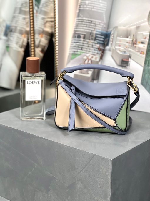 LOEWE Mini Puzzle Bag. Authentic quality luxury bag crafted in genuine leather comes with authenticity card, dust bag and gift bag. Cuboid Shape Meets Precise Craftsmanship The debut bag for *OEWE by Creative Director Jonathan Anderson is the Puzzle bag. With its cuboid shape and precise cutting technique, it boasts distinctive geometric lines. This particular mini version has been expertly crafted using contrasting calfskins.