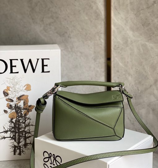 LOEWE Mini Puzzle Bag. Authentic quality luxury bag crafted in genuine leather comes with authenticity card, dust bag and gift bag. Cuboid Shape Meets Precise Craftsmanship The debut bag for *OEWE by Creative Director Jonathan Anderson is the Puzzle bag. With its cuboid shape and precise cutting technique, it boasts distinctive geometric lines. This particular mini version has been expertly crafted using contrasting calfskins.