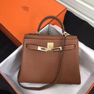 HERMÈS 'Kelly' Sellier Calf Leather Shoulder Bag. Original Quality Bag. Gold-metal toned Hardware. HERMÈS Sales Box and Dust Bag. Booklet, Authenticity Card, Payment Slip. Lock, key clochette, and two keys are included. 1930, a century after the house of HERMÈS opened the doors of its saddle-making workshops, Robert Dumas created a small bag with straps for ladies. It had a trapezoid shape, two triangular gussets, a sculpted flap, a handle, and good storage space. Nothing fancy, just a neat, plain, functional bag intended for independent, energetic women. The ladies’ bag with straps was an emblematic HERMÈS design: both highly desirable yet anonymous. 1956, Grace Kelly, the Hollywood star who became a princess, hides her baby bump behind her Hermès bag with straps. The picture goes around the world, and the bag is instantly crowned. The Kelly bag is born.