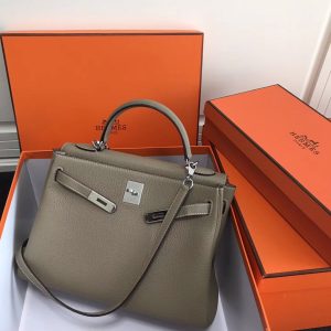 HERMÈS 'Kelly' Sellier Calf Leather Shoulder Bag. Authentic quality luxury bag crafted in genuine leather comes with authenticity card, dust bag and gift bag. Timeless Elegance, From Grace to Iconography. In 1930, a century after HERMÈS first opened its saddle-making workshops, Robert Dumas introduced a charming new creation for women - a small bag with straps. This bag featured a trapezoid shape, two triangular gussets, a sculpted flap, a handle, and ample storage space. Its design was simple and practical, tailored specifically for independent and energetic women. The bag with straps quickly became iconic for HERMÈS, embodying both desirability and discreetness. Then, in 1956, a significant moment occurred. Grace Kelly, the renowned Hollywood star turned princess, artfully concealed her baby bump behind her HERMÈS bag with straps. This image spread worldwide, instantly catapulting the bag into the limelight. And thus, the Kelly bag was born. - KRIS + KIKO HERMÈS 'Kelly' Sellier Calf Leather Shoulder Bag. Original Quality Bag. Gold-metal toned Hardware. HERMÈS Sales Box and Dust Bag. Booklet, Authenticity Card, Payment Slip. Lock, key clochette, and two keys are included. 1930, a century after the house of HERMÈS opened the doors of its saddle-making workshops, Robert Dumas created a small bag with straps for ladies. It had a trapezoid shape, two triangular gussets, a sculpted flap, a handle, and good storage space. Nothing fancy, just a neat, plain, functional bag intended for independent, energetic women. The ladies’ bag with straps was an emblematic HERMÈS design: both highly desirable yet anonymous. 1956, Grace Kelly, the Hollywood star who became a princess, hides her baby bump behind her Hermès bag with straps. The picture goes around the world, and the bag is instantly crowned. The Kelly bag is born.