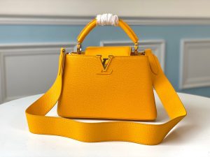 LOUIS VUITTON Capucines Mini. Authentic quality luxury bag crafted in genuine leather comes with authenticity card, dust bag and gift bag. Captivatingly vibrant. Effortlessly sophisticated. Crafted from vibrant Taurillon leather, the Capucines Mini handbag exudes an exquisite charm. Its striking color palette is tastefully enhanced by the understated metal handle rings. Just like every Capucines, this Mini version can be effortlessly carried with the flap out, adding an air of effortless elegance, or tucked inside to showcase the iconic LV Initials. - KRIS + KIKO LOUIS VUITTON Capucines Mini. Original Quality Bag including gift box, literature, dust bag, authenticity card. Fashioned from vibrantly colored Taurillon leather, the Capucines Mini handbag pops. The fresh new colorway is perfectly complemented by the discreet metal handle rings. Like all Capucines, the Mini can be carried with the flap out for simple sophistication or tucked inside to feature the LV Initials.