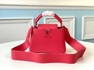 LOUIS VUITTON Capucines Mini. Authentic quality luxury bag crafted in genuine leather comes with authenticity card, dust bag and gift bag. Captivatingly vibrant. Effortlessly sophisticated. Crafted from vibrant Taurillon leather, the Capucines Mini handbag exudes an exquisite charm. Its striking color palette is tastefully enhanced by the understated metal handle rings. Just like every Capucines, this Mini version can be effortlessly carried with the flap out, adding an air of effortless elegance, or tucked inside to showcase the iconic LV Initials. - KRIS + KIKO LOUIS VUITTON Capucines Mini. Original Quality Bag including gift box, literature, dust bag, authenticity card. Fashioned from vibrantly colored Taurillon leather, the Capucines Mini handbag pops. The fresh new colorway is perfectly complemented by the discreet metal handle rings. Like all Capucines, the Mini can be carried with the flap out for simple sophistication or tucked inside to feature the LV Initials.