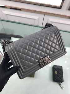 CHANEL Boy Quilted Leather Flap Bag. Authentic quality luxury bag crafted in genuine leather comes with authenticity card, dust bag and gift bag. Unveil Elegance: Elevate Your Style with CHANEL's Iconic Quilted Flap Bag. Elegantly designed, this exceptional CHANEL Boy quilted flap bag boasts a striking chain-link strap with a comfortable shoulder pad, a distinctive CC Boy logo push-lock closure, and exquisite antiqued hardware accents. Opening the push-lock closure reveals a luxurious black fabric-lined interior, complete with convenient side zip and slip pockets, perfect for securely organizing one's daily necessities. - KRIS + KIKO CHANEL Boy Quilted Leather Flap Bag. Original Quality Bag including gift box, literature, dust bag, authenticity card. This stand-out, enviable CHANEL Boy quilted flap bag features a chunky chain-link strap with shoulder pad, CC Boy logo push-lock closure, and antiqued hardware accents. Its push-lock closure opens to a black fabric-lined interior with side zip and slip pockets to secure daily essentials.