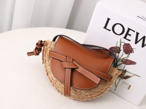 LOEWE Gate Mini Raffia Crossbody Bag. Original Quality Bag. Authentic Soft Calfskin and Woven Raffia. LOEWE Sales Box and Dust Bag. Booklet, Authenticity Card, Payment Slip. Finish off your look with this summery woven raffia iteration of Loewe's beloved Gate bag. The mini silhouette features a contrasting flap closure, which has been made from calf leather with an elegant knot detail wrapping over the front. Think of it as the sort of piece that you'll buy now but love forever.